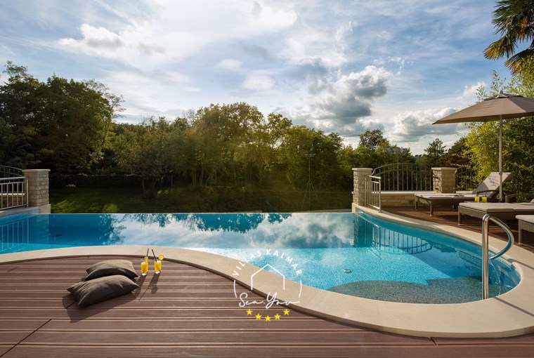 Poolside relaxation area at Villa Vlastelini I with garden views