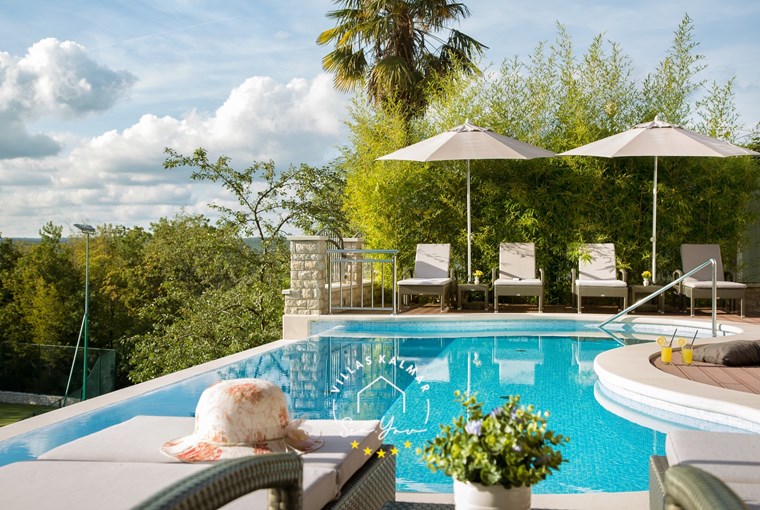 Heated outdoor pool at Villa Vlastelini I in Labin-Rabac surrounded by century-old oak trees