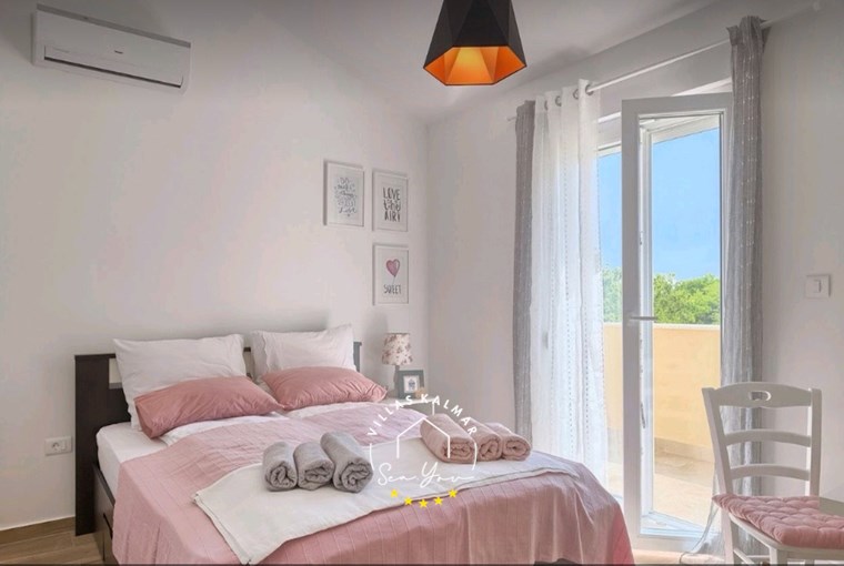 Udobna pastelna spavaća soba s balkonom u vili