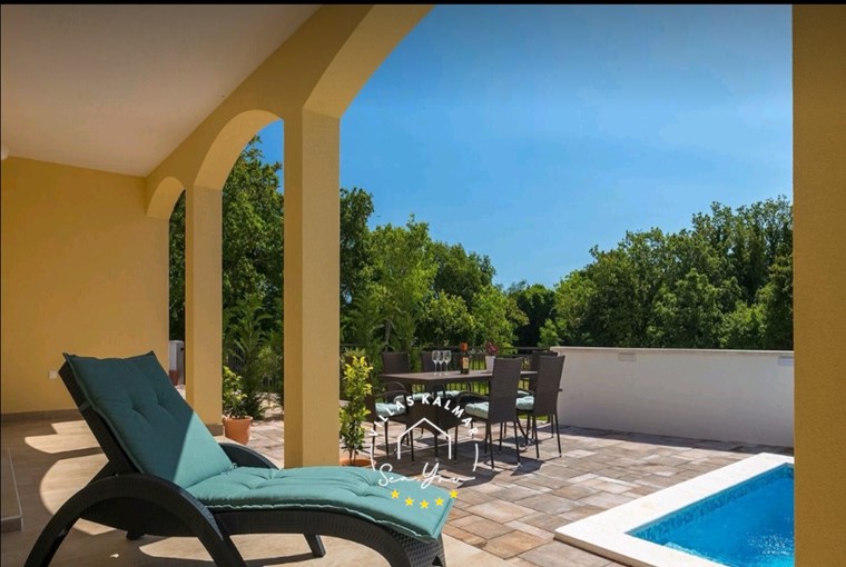 Ležaljka i vanjski blagovaonički prostor pokraj bazena vile