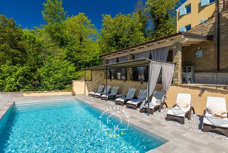 Sun loungers next to private pool of villa surrounded by nature