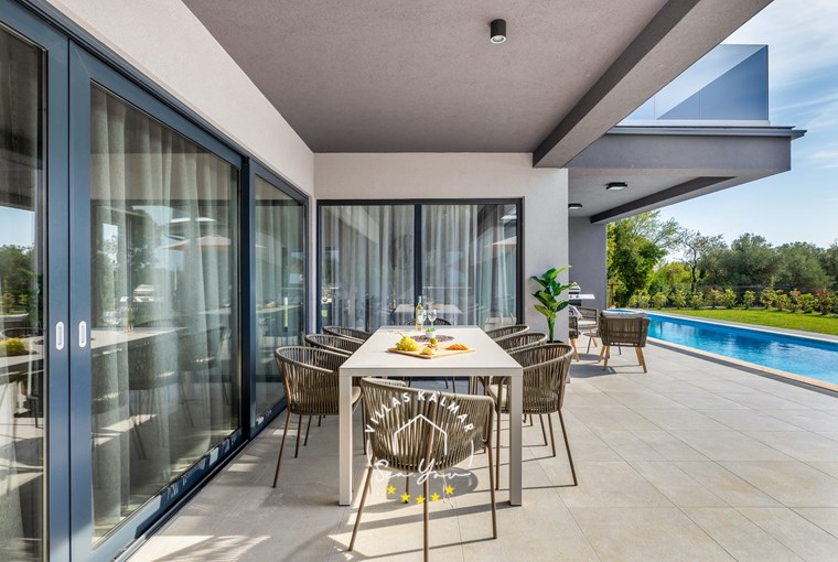 Covered terrace with garden furniture beside the pool