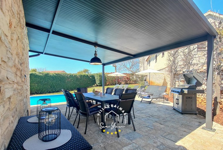 Outdoor dining area next to private pool of villa