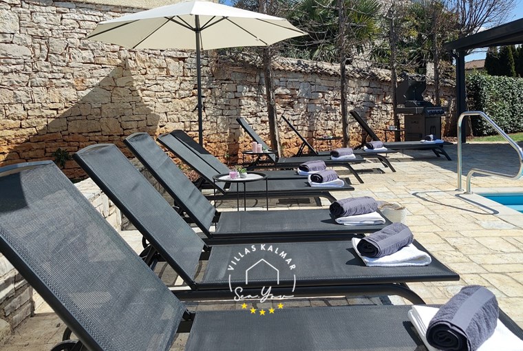 Sunloungers next to private pool of villa