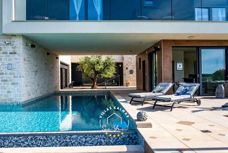 Sonnenliegen neben privatem Pool einer Villa