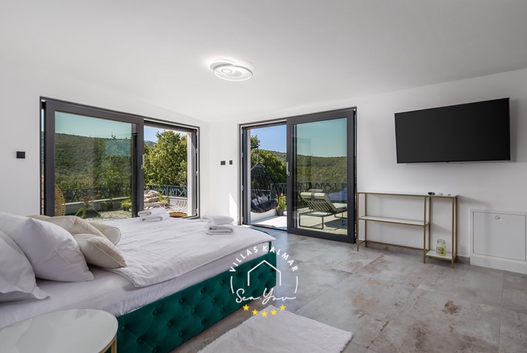 Open-space attic bedroom with freestanding bathtub and sea view