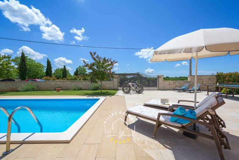 Sun loungers for relaxing next to pool of villa