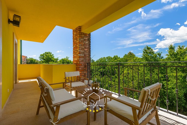 Covered outdoor seating area on the terrace overlooking the green surroundings in Villa Angeli close to Opatija