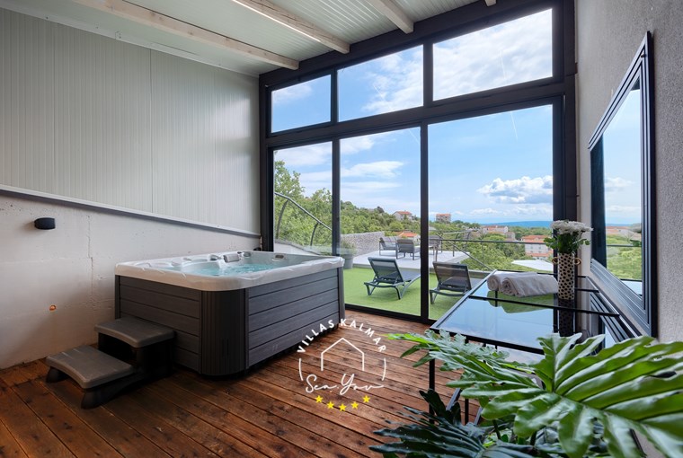 Spa room with hot tub and glass wall overlooking the pool area in luxury Villa Lavinia near Opatija