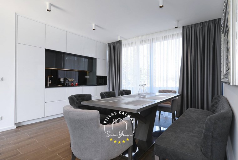 Modern and elegantly furnished kitchen with dining table and balcony doors in Villa K1 on Pasman