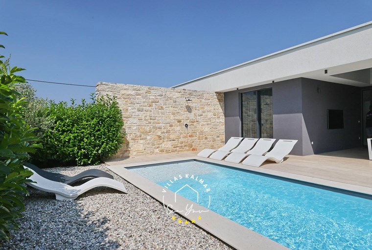 Private pool with sun loungers and a lounge area with TV in modern Villa K1 on the Island of Pasman