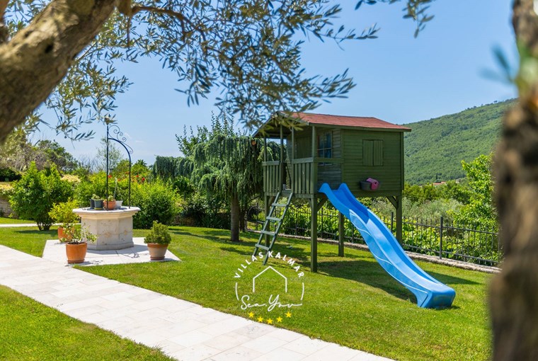 Children's playground with slide in the green garden of Villa Stonegate Estate near Opatija