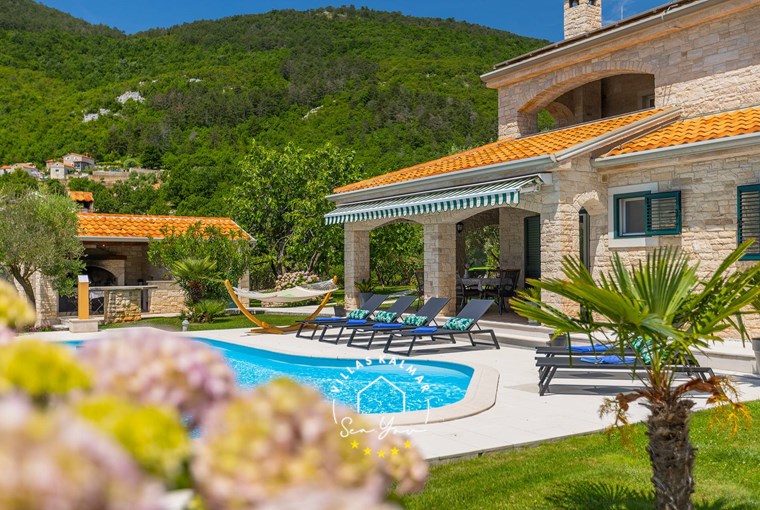 View over the garden with private pool, sun loungers and flowers in villa near Opatija