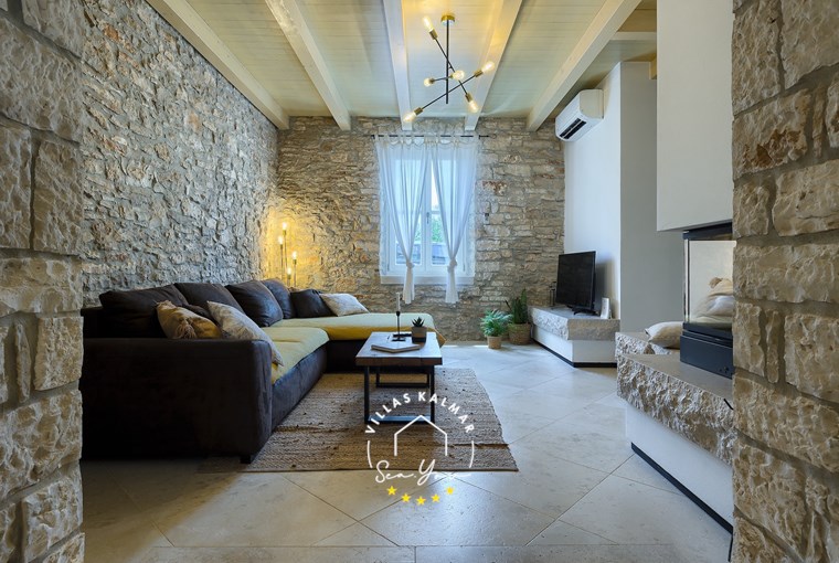 Cosy living room with fireplace and stone details – Villa Onelia