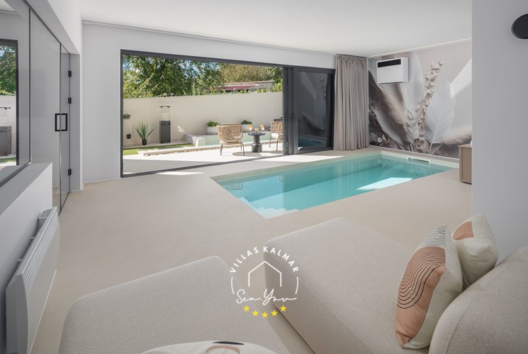 Sunlit interior with modern design and large glass walls at Villa Amoreta in Labin-Rabac