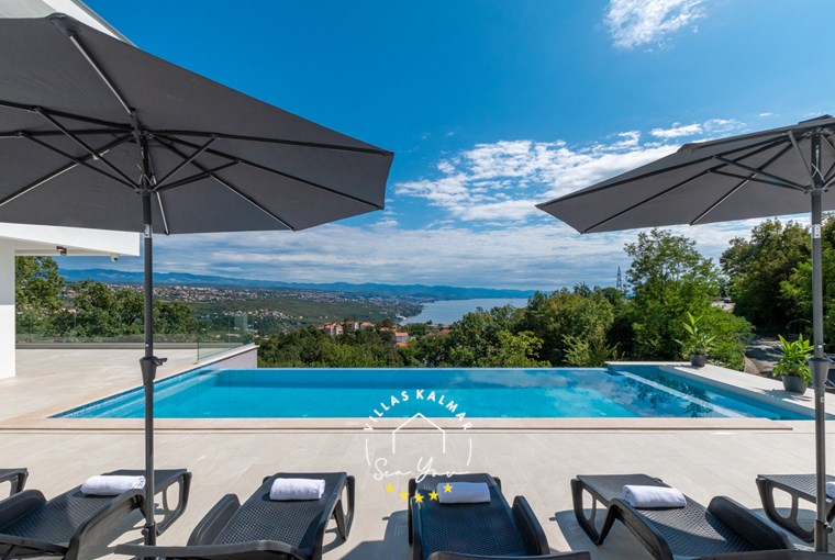 Sun loungers and parasols next to the private pool in Villa Gabi overlooking the Kvarner Bay