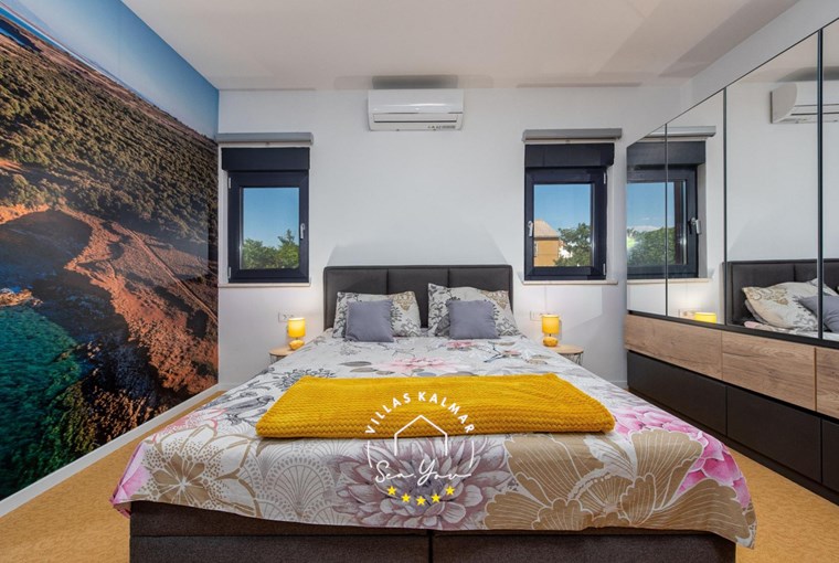 Spacious bedroom with double bed and wardrobe in villa on the island Vir