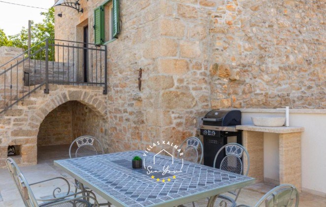 Charming outdoor dining area with BBQ and the entrance to the renovated stone Villa Andrea