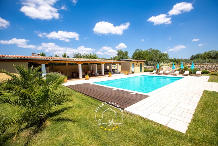 Private pool with covered outdoor dinign area and sun loungers with parasols in Villa Bozini Dvori