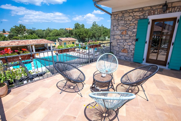 Outdoor seating area on the veranda on the upper floor with view over the pool area in restored Villa Bozini Dvori, Zadar