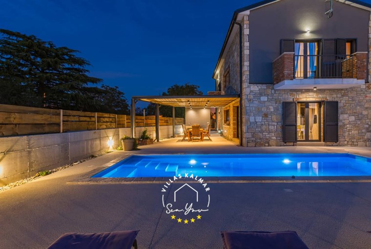 Outdoor area of Villa Baraka with private pool and covered dining area at night, near Rovinj in Istria