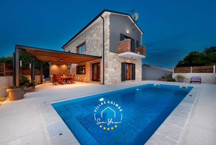 Villa Baraka with private outdoor pool and covered dining area at night