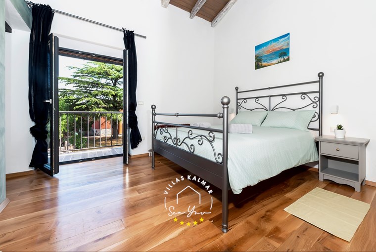 Bright bedroom with double bed and balcony in Villa Baraka, Istria