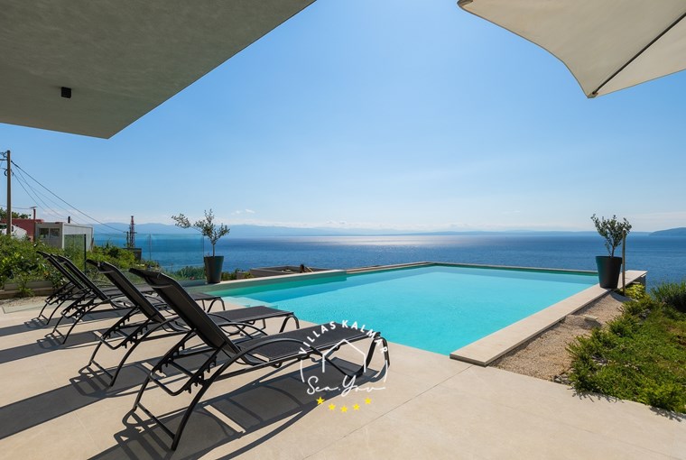 Sun loungers next to private pool with panoramic sea view of villa