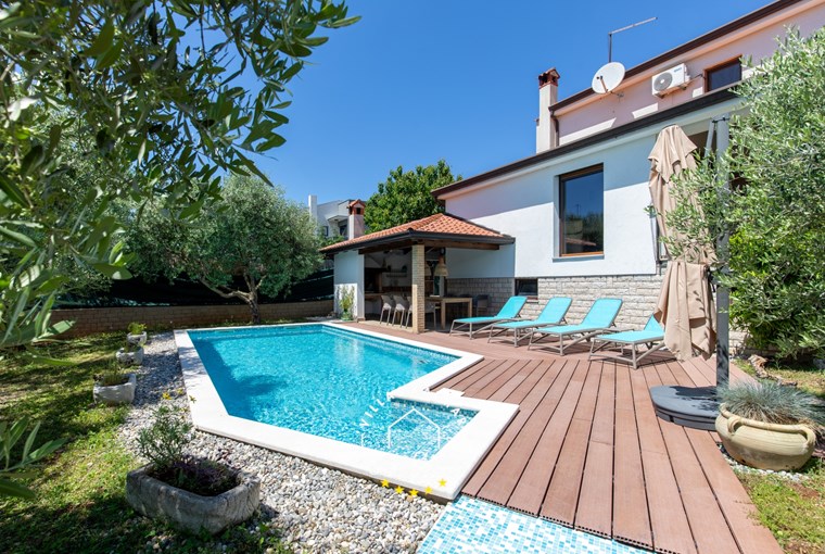 Private pool of villa with sun loungers and parasol
