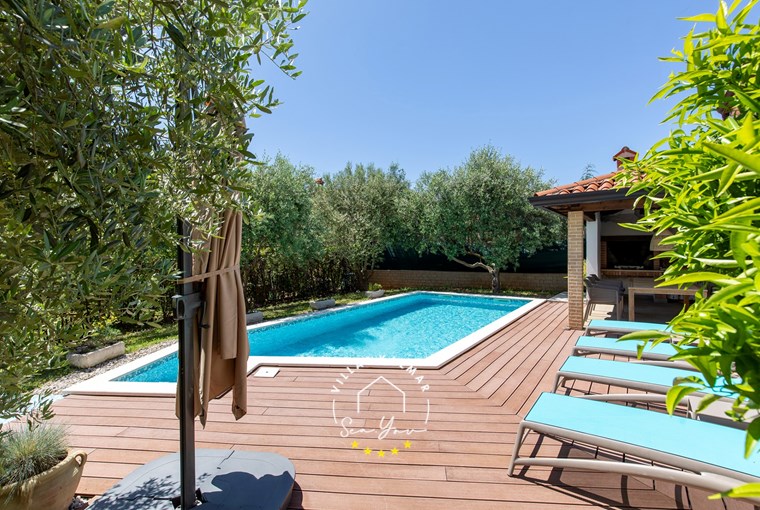 Private pool of villa with sun loungers and parasol