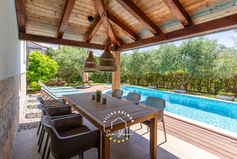 Outdoor dining table next to the private pool of the villa near Porec
