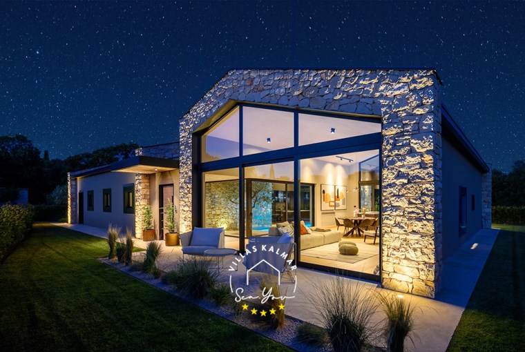 Lounge area next to glass walls in garden of Villa CasaNova in Bale